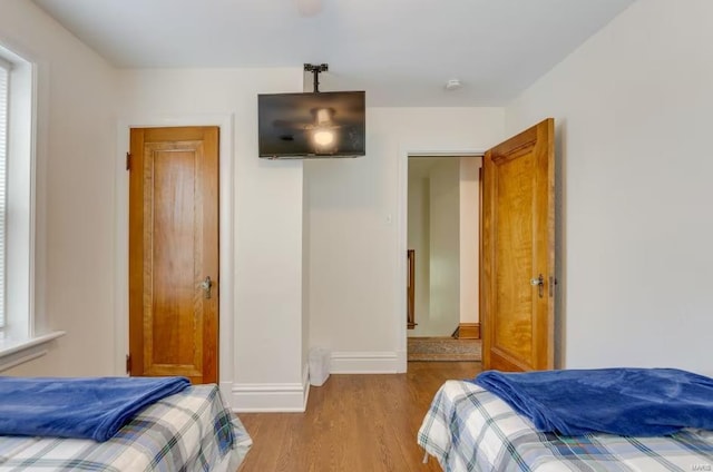 bedroom with light hardwood / wood-style flooring and multiple windows