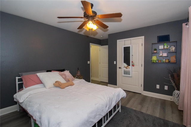 bedroom with a closet, dark hardwood / wood-style floors, and ceiling fan