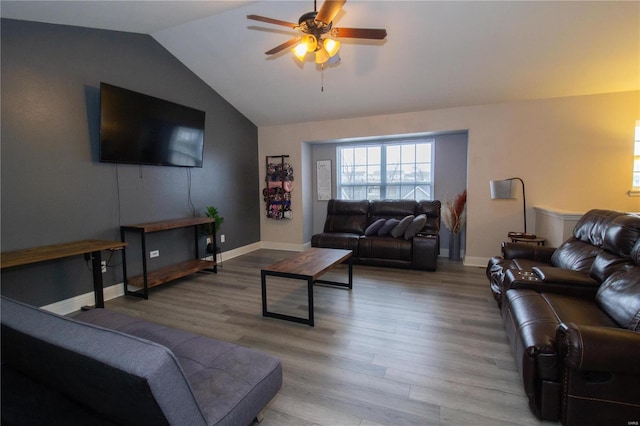 living room featuring hardwood / wood-style flooring, ceiling fan, and vaulted ceiling