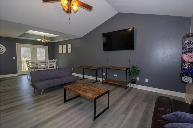 living room with hardwood / wood-style flooring, ceiling fan with notable chandelier, and lofted ceiling