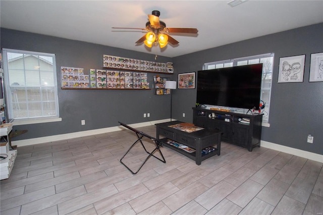 living room featuring ceiling fan and a wealth of natural light