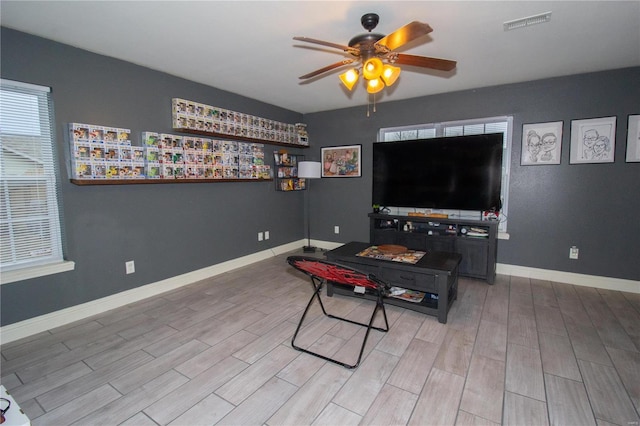 living room with ceiling fan and light hardwood / wood-style flooring