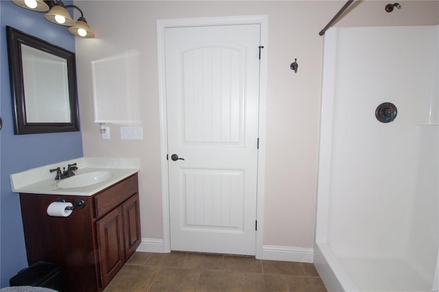 bathroom with a shower, tile patterned floors, and vanity