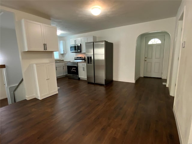 kitchen featuring dark wood-type flooring, stainless steel appliances, and white cabinets