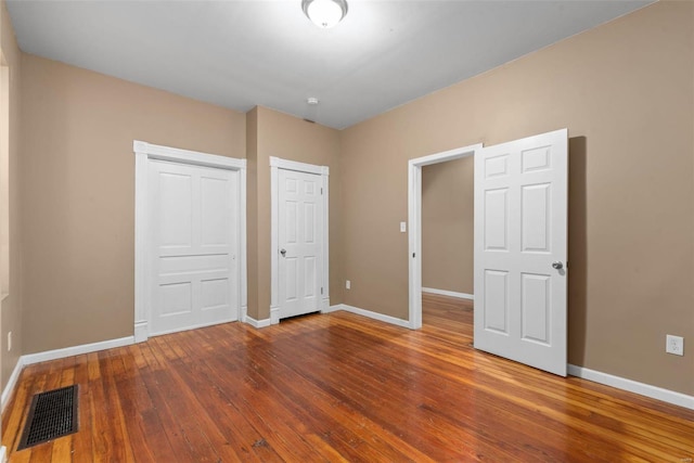 unfurnished bedroom with hardwood / wood-style flooring and a closet