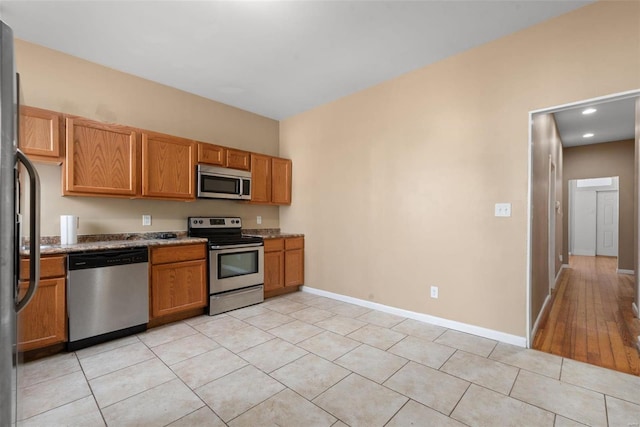 kitchen with stainless steel appliances and light tile patterned flooring