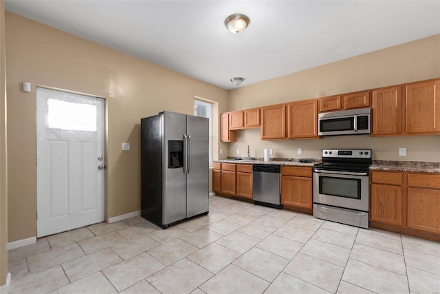 kitchen featuring light tile patterned floors, sink, and appliances with stainless steel finishes