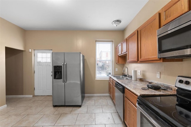 kitchen with stainless steel appliances, sink, and light tile patterned floors