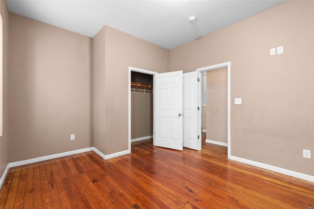 unfurnished bedroom with hardwood / wood-style flooring and a closet