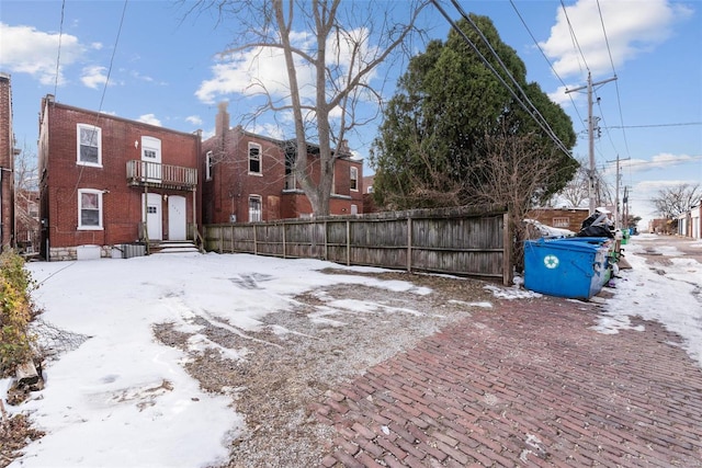 yard covered in snow with a balcony