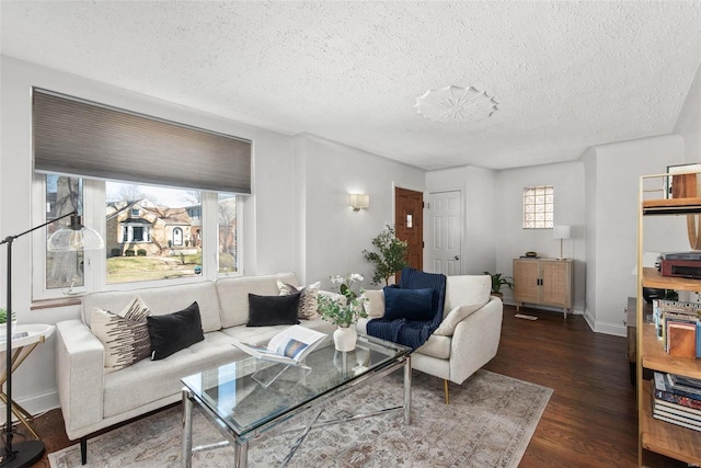 living room featuring dark wood-style floors, a textured ceiling, and baseboards