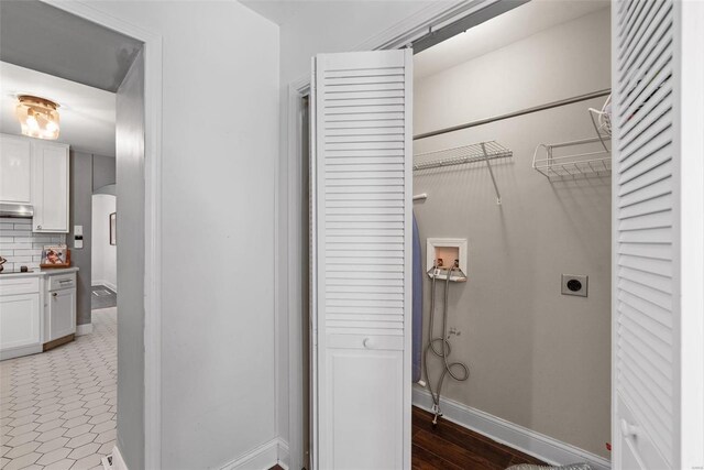 laundry room featuring baseboards, laundry area, hookup for a washing machine, arched walkways, and electric dryer hookup