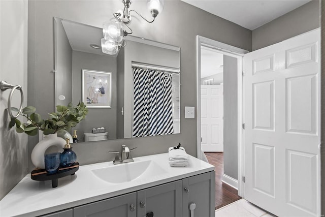 full bathroom with toilet, an inviting chandelier, and vanity