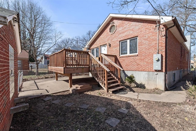 rear view of property with a patio, stairway, fence, a deck, and brick siding