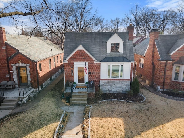 view of front of property with stone siding and a front lawn