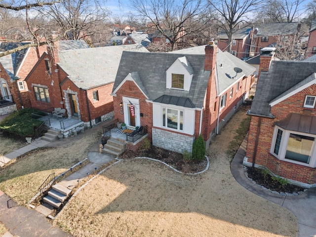 view of front of property with stone siding, brick siding, and a chimney