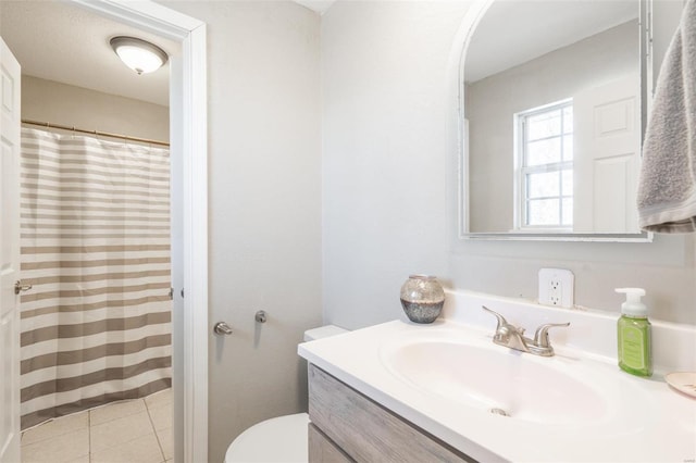 bathroom with toilet, tile patterned flooring, and vanity