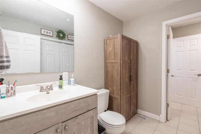 bathroom with toilet, tile patterned floors, and vanity