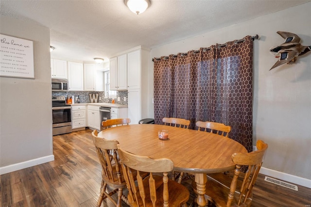 dining room featuring a textured ceiling and hardwood / wood-style floors