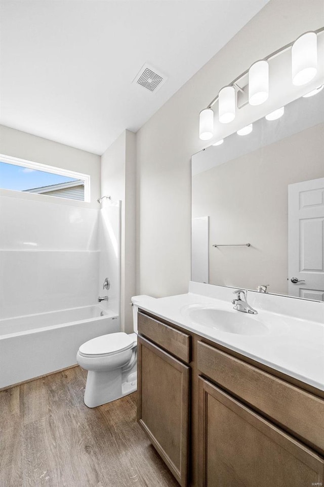 full bathroom featuring bathtub / shower combination, vanity, toilet, and hardwood / wood-style floors