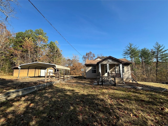 exterior space with a carport, a porch, and a front yard