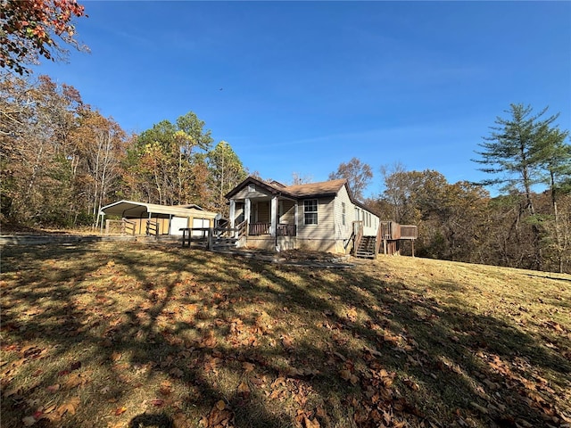 view of front of home with a front lawn, a carport, and a porch