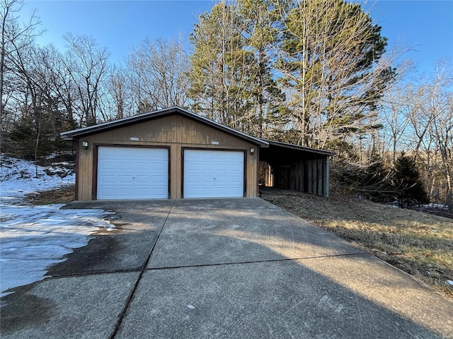 snow covered garage featuring a carport