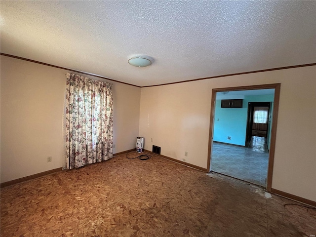 unfurnished room with ornamental molding and a textured ceiling