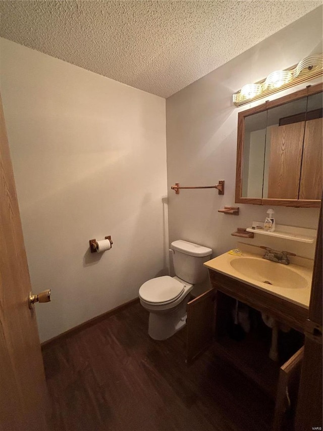 bathroom with wood-type flooring, sink, a textured ceiling, and toilet