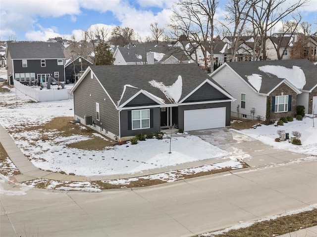 view of front of home with a garage and central AC