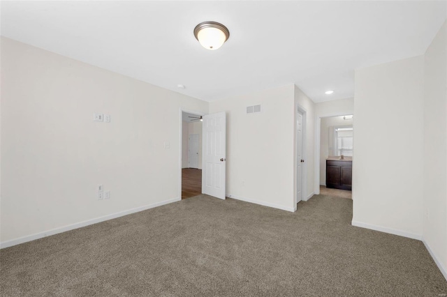 unfurnished bedroom featuring carpet flooring, visible vents, and baseboards