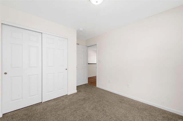 unfurnished bedroom featuring a closet, carpet, and baseboards