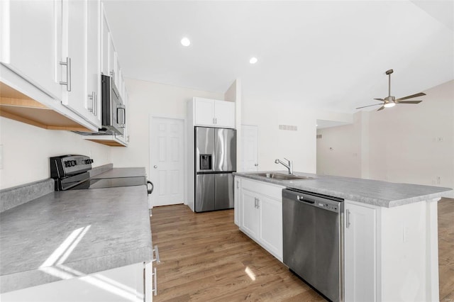 kitchen featuring appliances with stainless steel finishes, a kitchen island with sink, white cabinets, and a sink