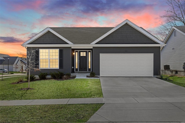 view of front of property featuring concrete driveway, an attached garage, and a lawn