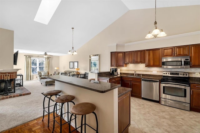 kitchen with stainless steel appliances, a kitchen breakfast bar, decorative light fixtures, and backsplash