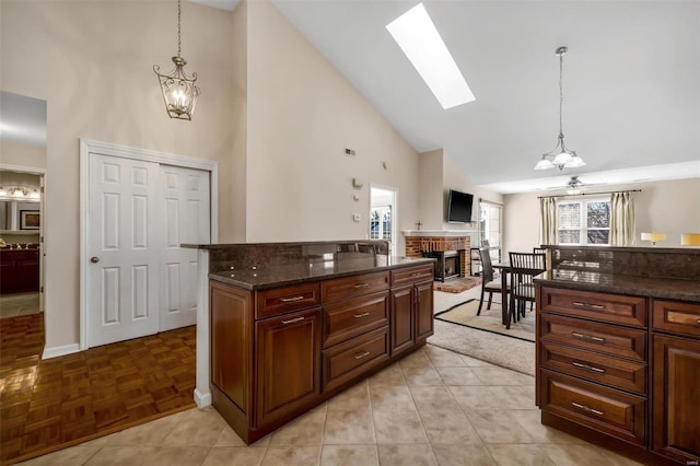 kitchen with pendant lighting, light parquet flooring, a fireplace, and high vaulted ceiling