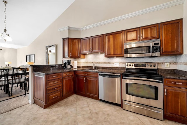 kitchen featuring pendant lighting, sink, lofted ceiling, backsplash, and stainless steel appliances