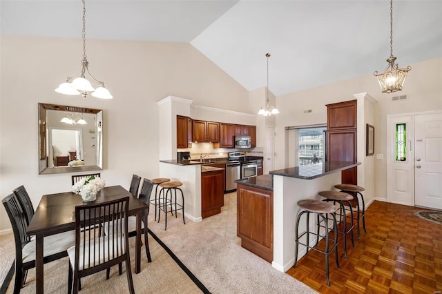 kitchen featuring a center island, appliances with stainless steel finishes, a breakfast bar, and high vaulted ceiling