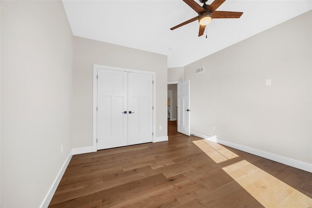 unfurnished bedroom featuring ceiling fan, wood-type flooring, and a closet