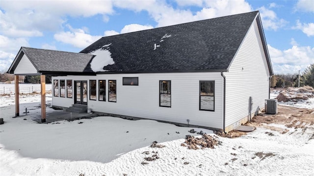 snow covered rear of property with cooling unit