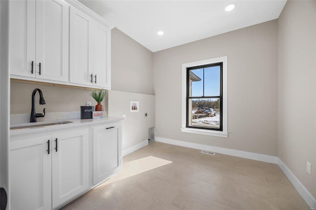 clothes washing area with hookup for a washing machine, baseboards, a sink, cabinet space, and electric dryer hookup