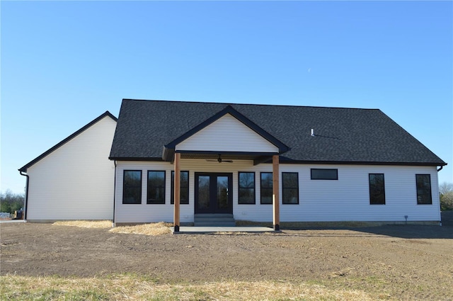 rear view of property featuring entry steps, ceiling fan, and roof with shingles