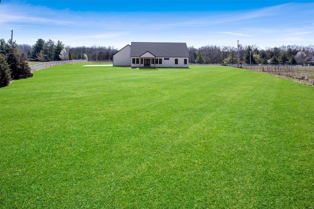 view of yard with fence and a rural view