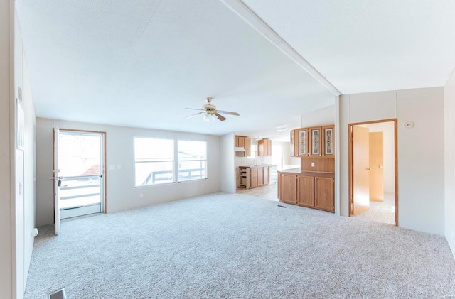 unfurnished living room with ceiling fan and light colored carpet