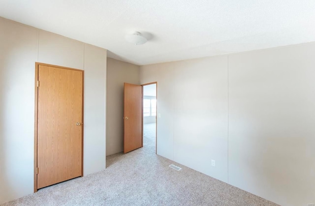 unfurnished bedroom featuring light carpet