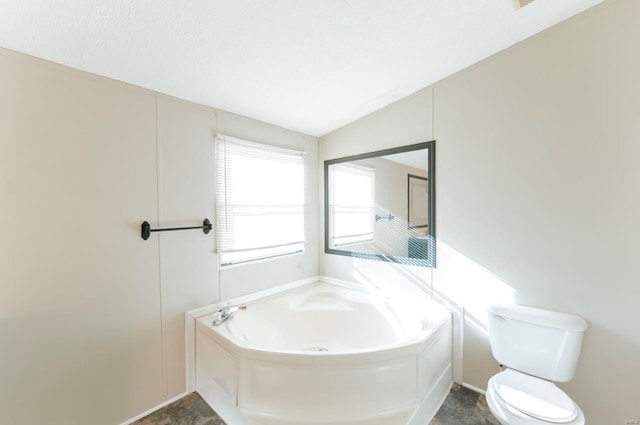 bathroom featuring toilet, a bathtub, and vaulted ceiling