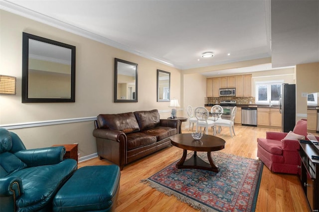 living area with crown molding and light wood-style flooring