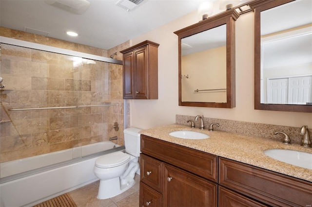 bathroom featuring toilet, tile patterned flooring, double vanity, and a sink