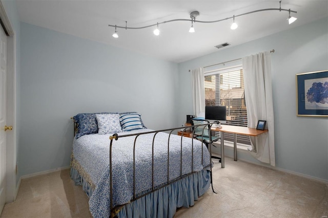 bedroom featuring baseboards, track lighting, visible vents, and light colored carpet