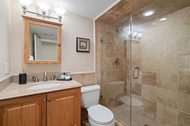 bathroom featuring toilet, vanity, visible vents, tile walls, and a stall shower